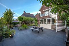 Dijktuin met strakke tegels en verhoogde plantvakken in Papendrecht