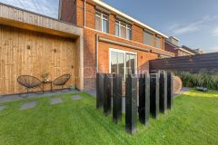 Strakke design staanders in het gazon om het terras