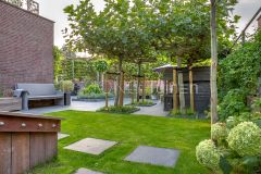 Strakke dijktuin met staptegels in gazon