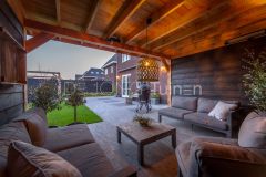 Gezellige zithoek onder houten overkapping in sfeervolle tuin in Papendrecht, inclusief tuinverlichting