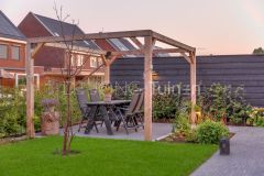 Strak aangelegde tuin in Papendrecht met houten pergola, tuintafel en moderne sierbestrating