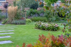 Detail foto staptegels in gazon en ronde border