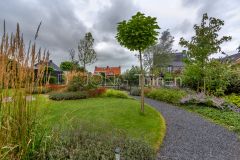 Organische vormen gazon, grindpad en mooie beplanting