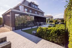 Brede achtertuin met klinkers